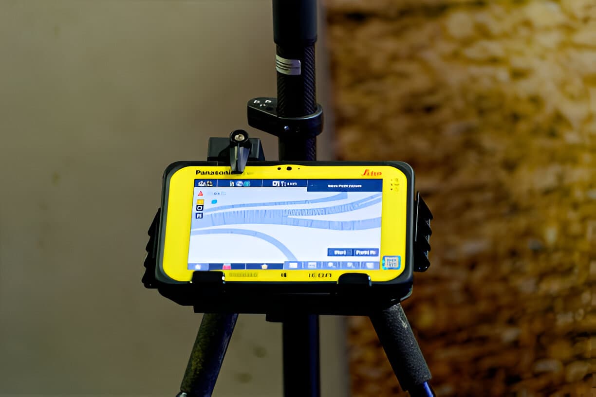 GNSS survey controller mounted on a pole showing live map data