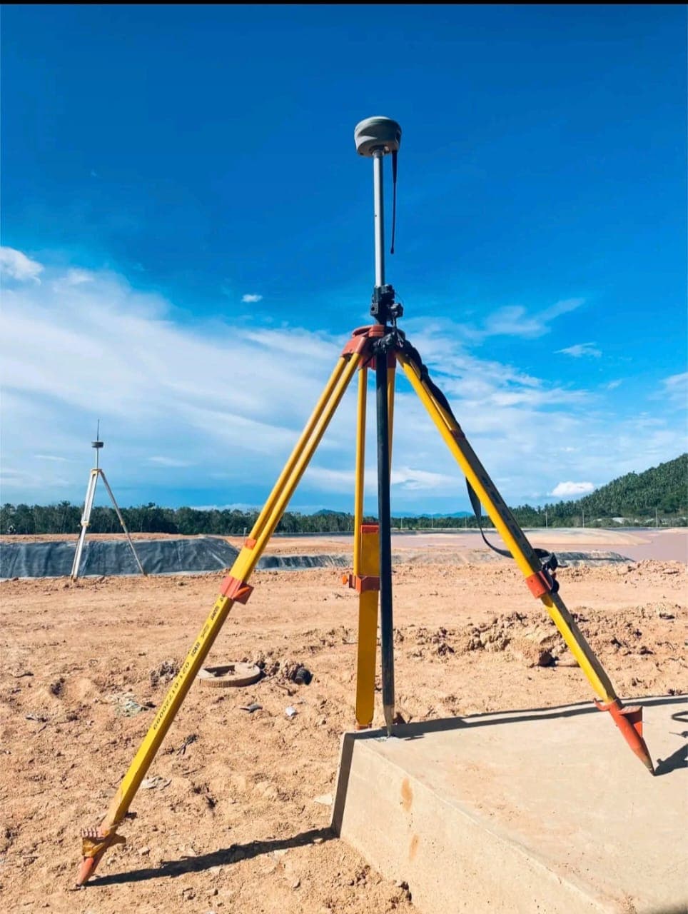 RTK GNSS receiver on a tripod verifying a plot beacon